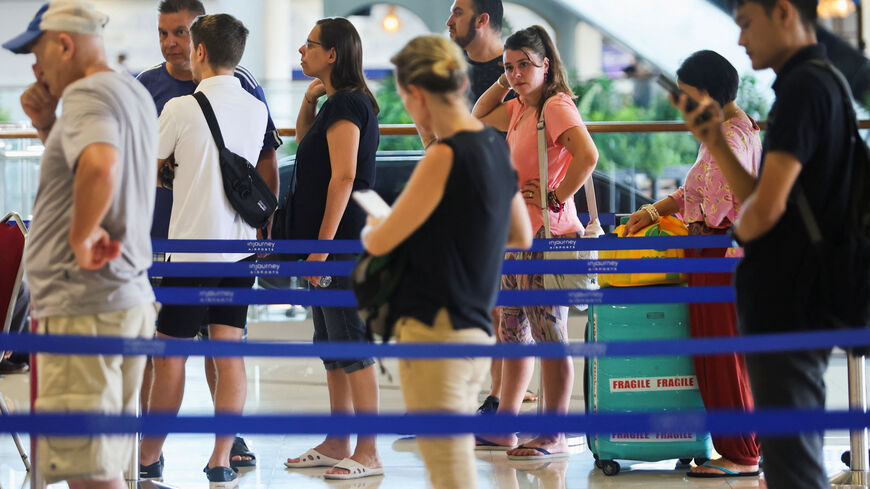 Stranded passengers stand in line at the Qatar Airways customer service at I Gusti Ngurah Rai International Airport after flights to Doha, Dubai, and Abu Dhabi were cancelled following strikes on Iran launched by the United States and Israel, in Kuta, Bali, Indonesia, March 1, 2026. REUTERS/Johannes Christo