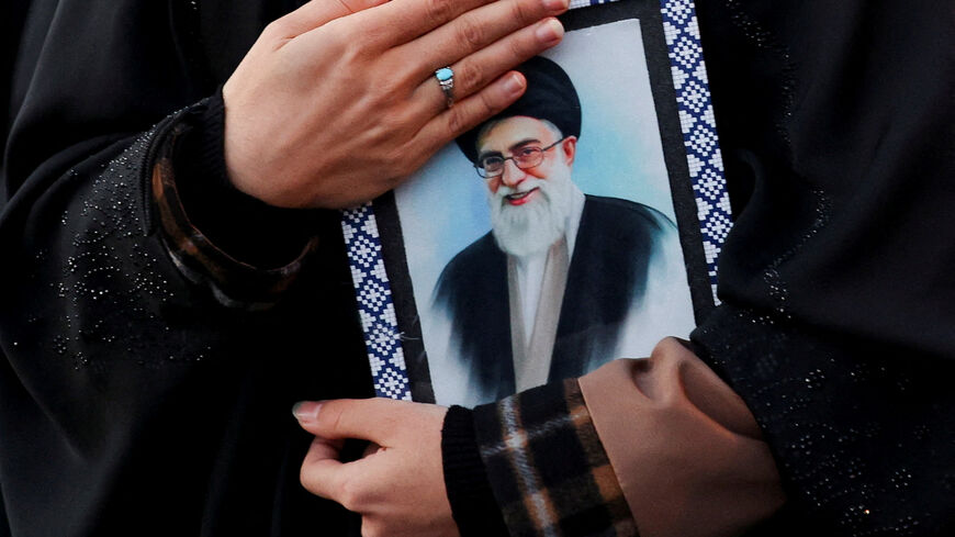 FILE PHOTO: A woman holds on to a picture of Iran's Supreme Leader Ayatollah Ali Khamenei at the Enghelab Square, after he was killed in Israeli and U.S. strikes on Saturday, in Tehran, Iran, March 1, 2026. Majid Asgaripour/WANA (West Asia News Agency) via REUTERS/File Photo