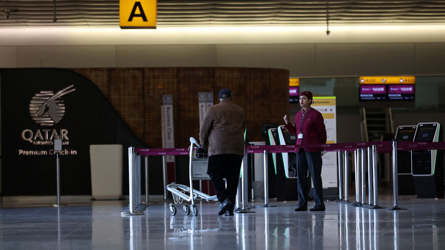An employee of Qatar Airways informs a traveller at a closed check-in area amid the U.S.-Israel conflict with Iran, at Heathrow Airport Terminal 4, in Greater London, Britain, March 2, 2026. REUTERS/Isabel Infante