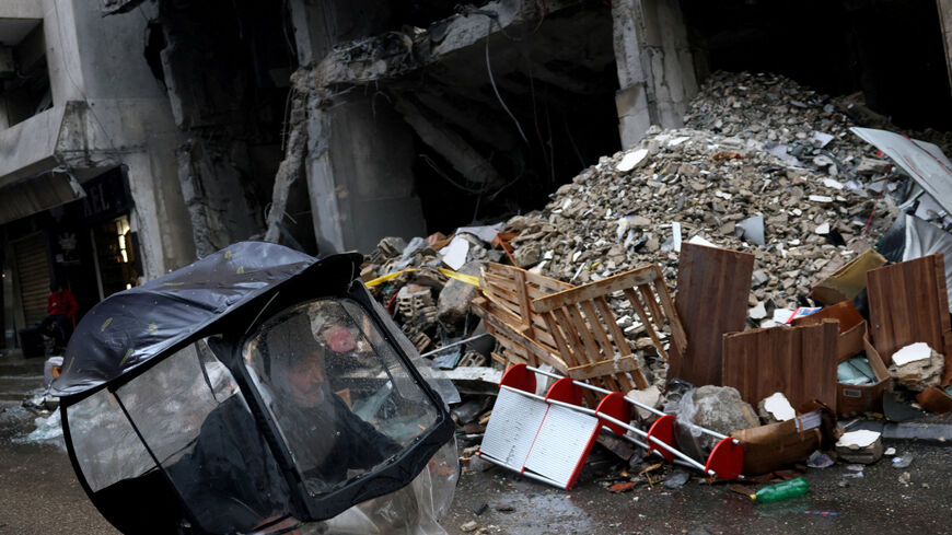 A man rides a scooter next to a damaged building in the aftermath of an Israeli strike in central Beirut, targeting what Israel said is a Hezbollah-affiliated bank, following an escalation between Hezbollah and Israel amid the U.S.-Israeli conflict with Iran, in Beirut, Lebanon, March 15, 2026. REUTERS/Claudia Greco