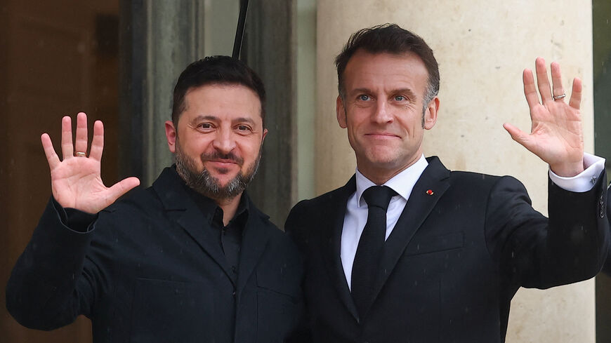 French President Emmanuel Macron and Ukrainian President Volodymyr Zelenskiy wave, as President Zelenskiy arrives for a meeting at the Elysee Palace in Paris, France, March 13, 2026. REUTERS/Gonzalo Fuentes