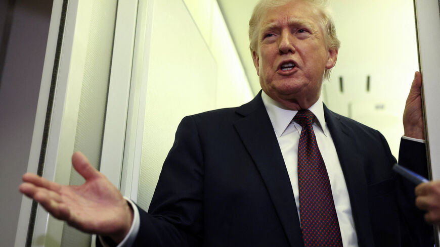 U.S. President Donald Trump speaks to reporters aboard Air Force One on a flight back to Washington March 15, 2026. REUTERS/Kevin Lamarque