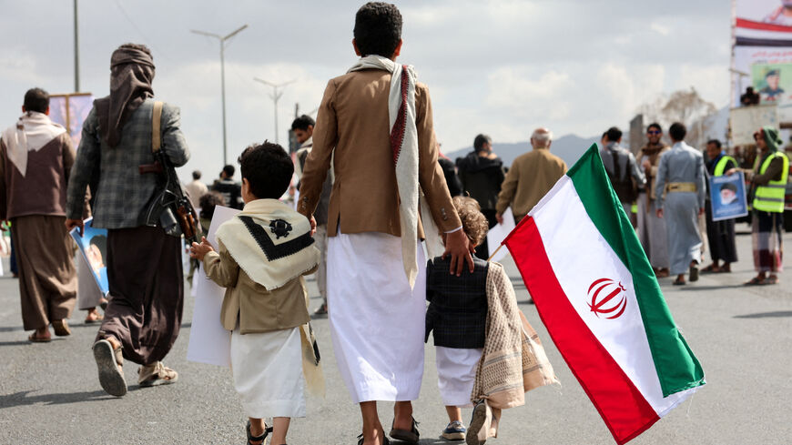 A person walks with children as Houthi supporters demonstrate in solidarity with Iran and Lebanon, amid the U.S.-Israeli conflict with Iran, in Sanaa, Yemen. REUTERS/Khaled Abdullah