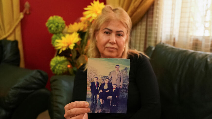 Sofia Ben Agla, wife of detained opposition leader Ghazi Chaouachi, poses for the camera while holding an old photo of herself, her husband, and their two sons inside her home in Tunis, Tunisia, on February 26, 2026. REUTERS/Stringer