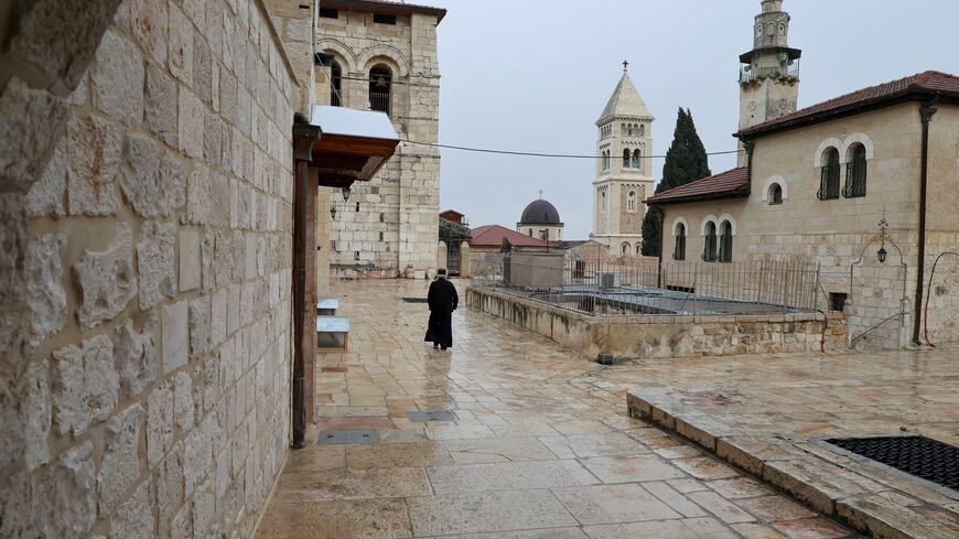 A person walks near the Church of the Holy Sepulchre as it is locked following the cancellation of the traditional Palm Sunday procession from the Mount of Olives, amid restrictions on gathering in large groups and the U.S.-Israel conflict with Iran, in Jerusalem's Old City March 29, 2026. REUTERS/Ammar Awad