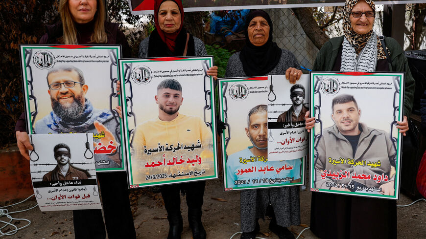Palestinians hold placards as they take part in a protest against the execution of the Israeli death penalty law for Palestinians convicted of lethal attacks, in Ramallah in the Israeli-occupied West Bank, March 31, 2026. REUTERS/Mohammed Torokman