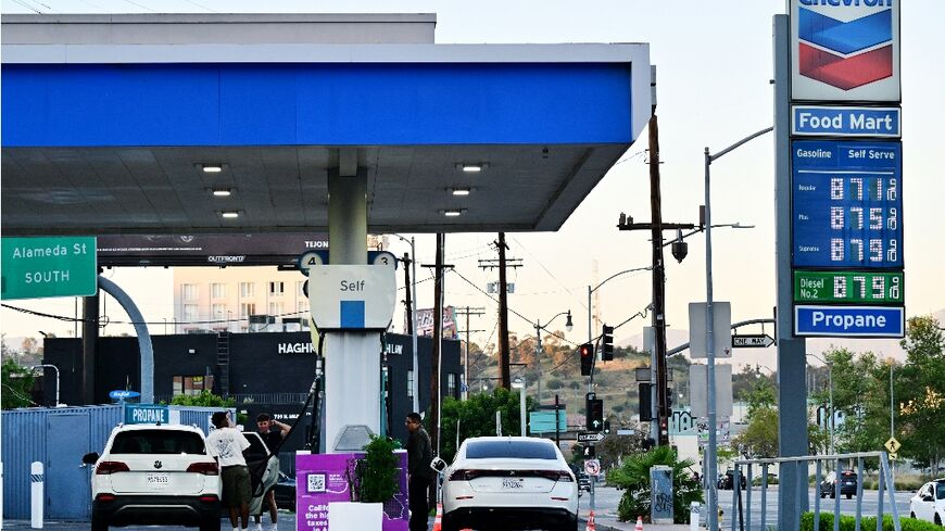 The sign of a Chevron gas station displays current prices as drivers pump gas in Rosemead, near Los Angeles, California in March 2026