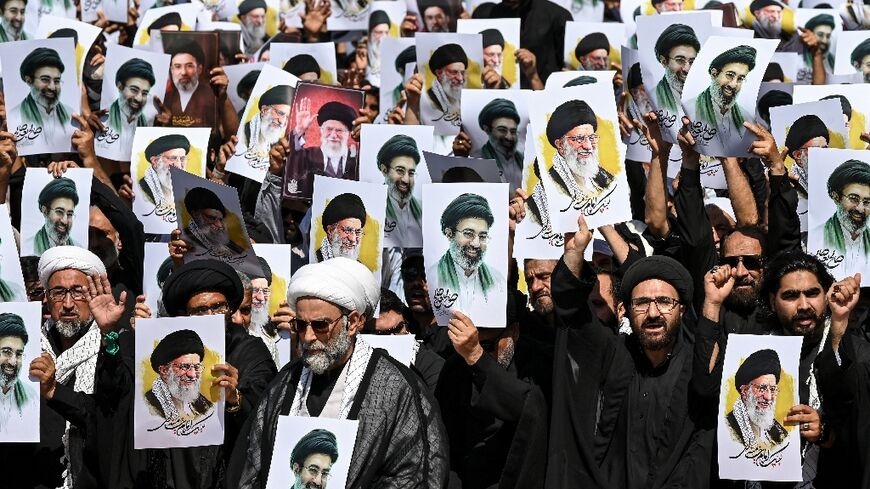 Shia Muslims holding portraits of Iran's slain supreme leader, Ali Khamenei, and his son, new supreme leader Mojtaba Khamenei, shout anti-US and -Israel slogans during a procession in Karachi, Pakistan