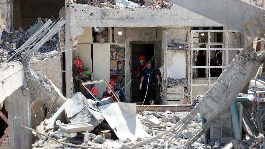 Firefighters at a bombed-out residential building in Tehran
