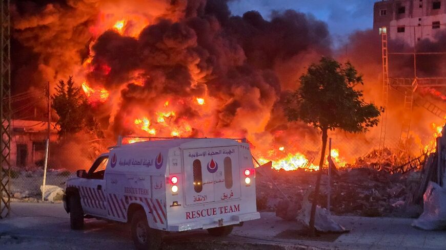 An ambulance is parked near a sweeping blaze following Israeli bombardment on a solar farm and electricity generation facility in Lebanon's southern coastal city of Tyre