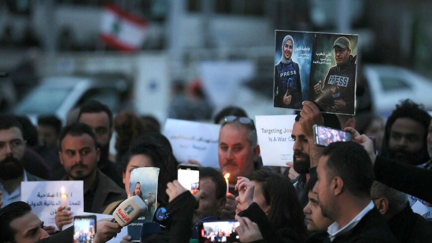 A Lebanese journalist holds pictures of Shoeib and Ftouni at a protest against their killing