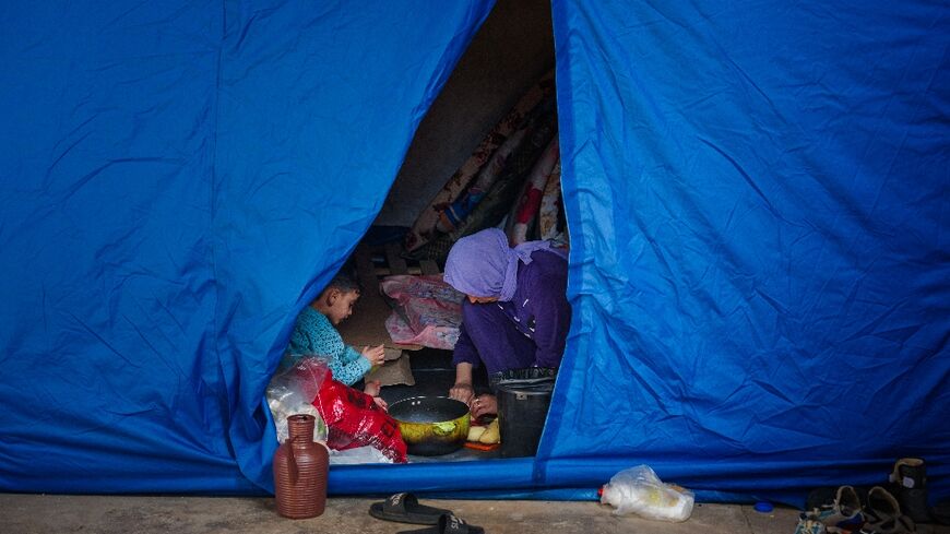 A woman cooks inside a tent at a stadium in the Lebanese capital Beirut converted into a shelter for people displaced by the conflict