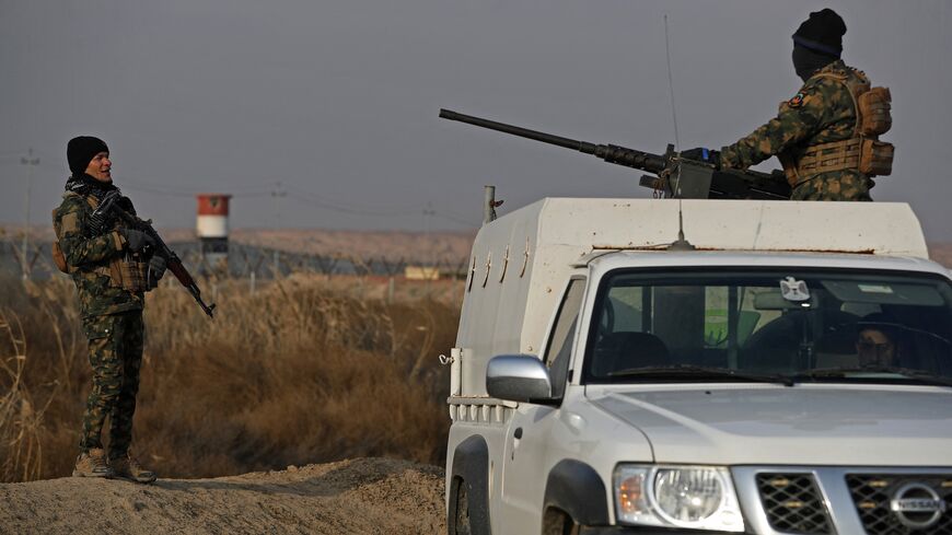 Members of the Popular Mobilization Units stand guard along the Iraqi-Syrian border in Al-Qaim, west of Iraq, on Jan. 23, 2026. 