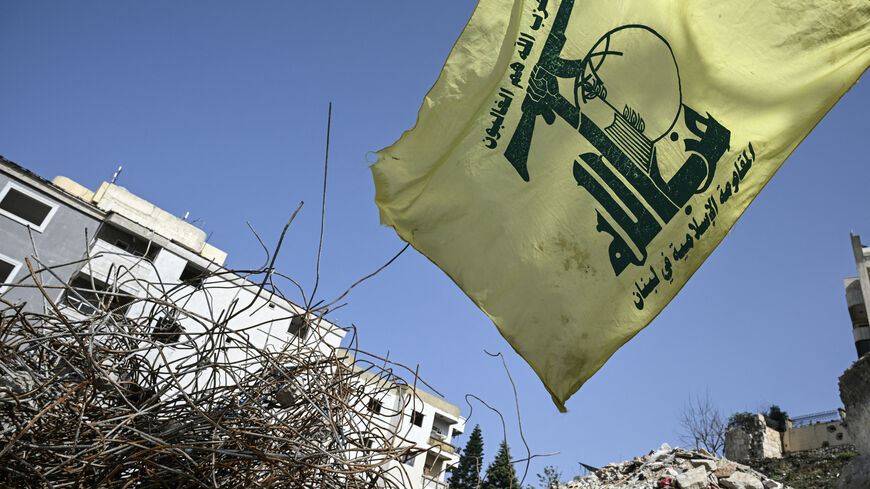 A flag of the Lebanese Shiite movement Hezbollah flutters above the rubble of a building that was hit in January by an Israeli strike in the southern Lebanese village of Qannarit, on Feb. 16, 2026.