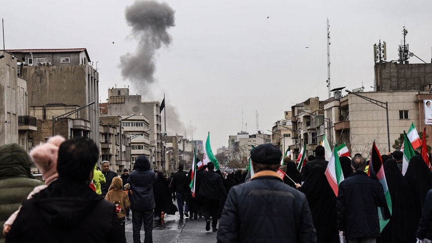 Black smoke rises following an airstrike, as Iranians take part in the Al-Quds (Jerusalem) Day rally, a commemoration in support of the Palestinian people on the last Friday of the Islamic holy month of Ramadan, in Tehran on March 13, 2026. 