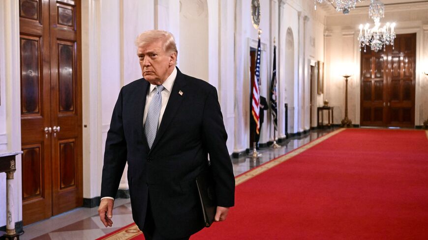 US President Donald Trump walks through the Cross Hall as he arrives for a ceremony to present the Commander-in-Chief Trophy to the Navy Midshipmen football team of the United States Naval Academy in the East Room of the White House in Washington, DC, on March 20, 2026. (Photo by Brendan SMIALOWSKI / AFP via Getty Images)