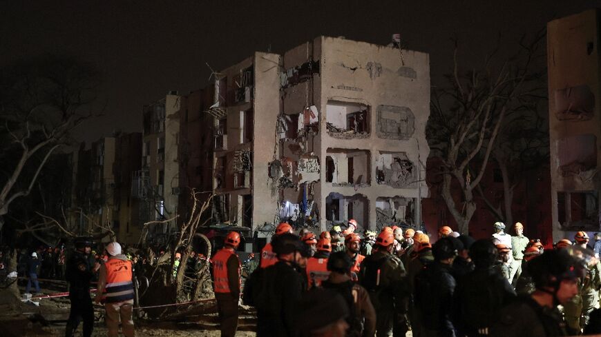 First responders inspect the site of an Iranian missile strike in the Israeli town of Arad on March 22, 2026