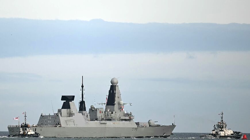 The HMS Dragon is guided by tugboats as it departs Portsmouth, on the south coast of England