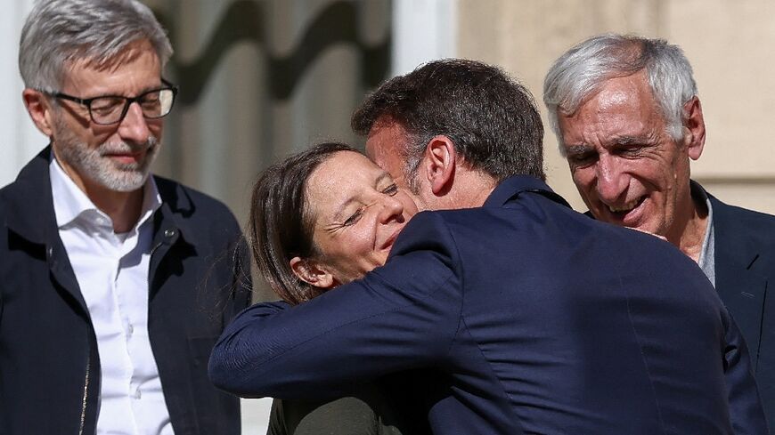 French President Emmanuel Macron embraced Cecile Kohler (centre) and Jacques Paris (right) as they arrived at the Elysee