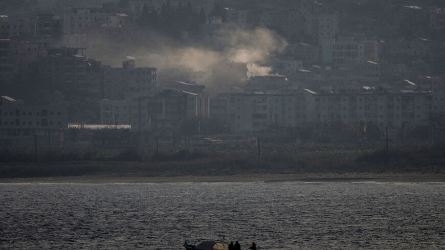 FILE PHOTO: Fishermen sail their boat as smoke from an Israeli airstrike rises in Abbassiye area in Tyre, Lebanon, April 14, 2026. REUTERS/Louisa Gouliamaki/File Photo