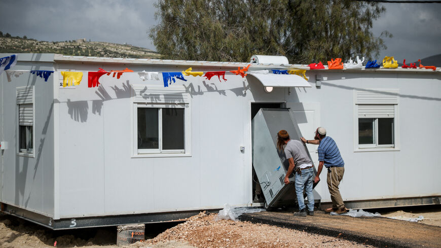 Israeli settlers move an appliance inside an house, on the day of the re-establishment of the settlement of Sa-Nur, which was evacuated as part of Israel’s 2005 disengagement, in Sa-Nur in the Israeli-occupied West Bank, April 19, 2026. REUTERS/Shir Torem