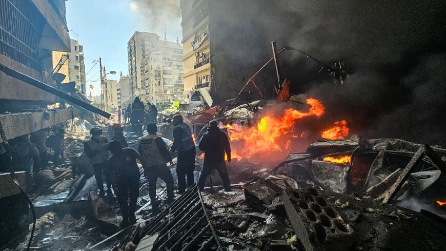 First responders stand amid rubble at the site of an Israeli airstrike in Beirut