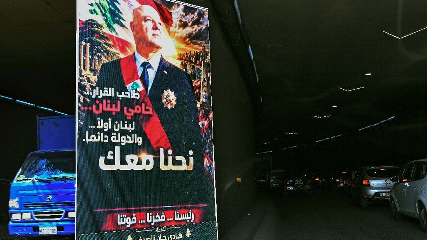 A poster depicting the portrait of Lebanon's President Joseph Aoun that reads "The decision-maker, the protector of Lebanon, Lebanon first...The State always. We are with you" hangs on a Beirut street
