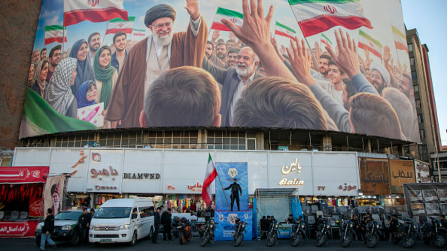 TEHRAN, IRAN - APRIL 23: A police officer stands holding a flag in Valiasr Square beneath a mural of the late Ayatollah Ali Khamenei on April 23, 2026 in Tehran, Iran. Earlier this week, U.S. President Donald Trump announced an extension of the current ceasefire between his country and Iran, despite Iran declining to attend the latest proposed round of peace talks in Islamabad. The focus of the war has shifted largely to the Strait of Hormuz, where both sides are trying to assert control over the critical m