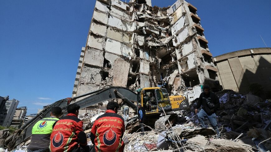 Lebanese rescuers clear the rubble at the site of an Israeli airstrike that targeted a building the day before in Beirut