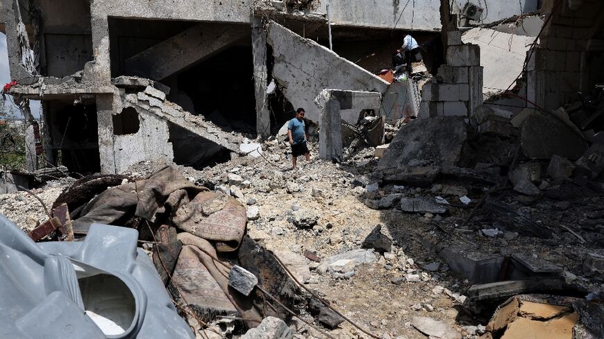 A young boy walks amid the rubble of a building destroyed in an Israeli strike in the southern Lebanese village of Kfar Sir on April 21, 2026