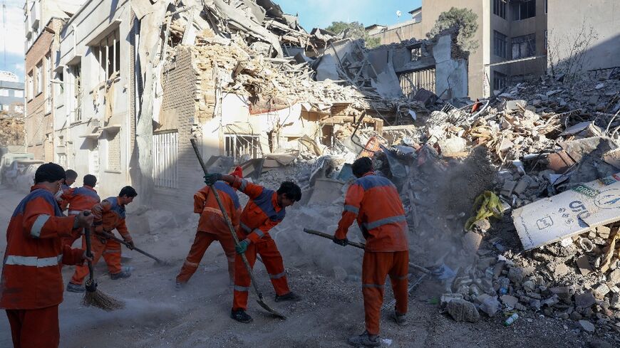 Workers clean clean where Israeli-US strikes destroyed the Rafi-Nia Synagogue and nearby residential buildings in Tehran, according to local media reports, on April 7 2026