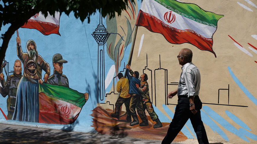 An Iranian man walks next to a mural on a street in Tehran, Iran, May 11, 2026. Majid Asgaripour/WANA (West Asia News Agency) via REUTERS