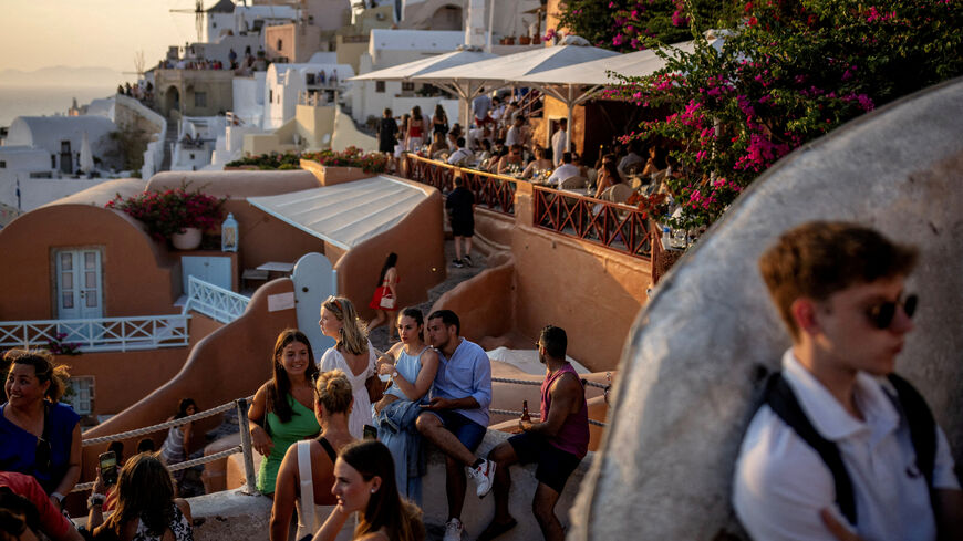 FILE PHOTO: Tourists wait to view Santorini’s famed sunset, on Santorini, Greece, July 25, 2024. REUTERS/Alkis Konstantinidis/File Photo