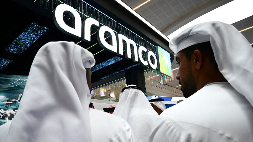 Guests stand at the Aramco booth during the Abu Dhabi International Petroleum Exhibition & Conference in Abu Dhabi on Nov. 3, 2025. 