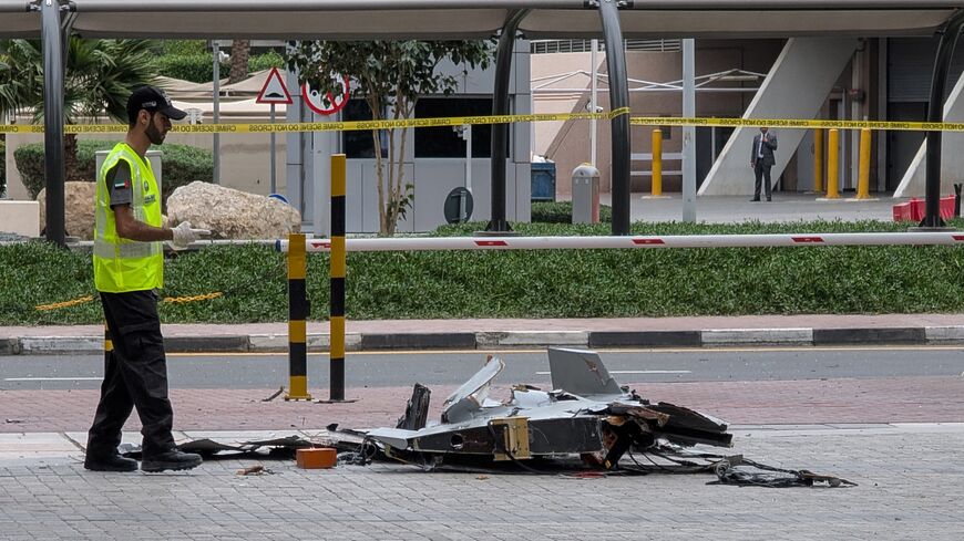 A policeman inspects the wreckage of a drone in downtown Dubai on March 12, 2026. 