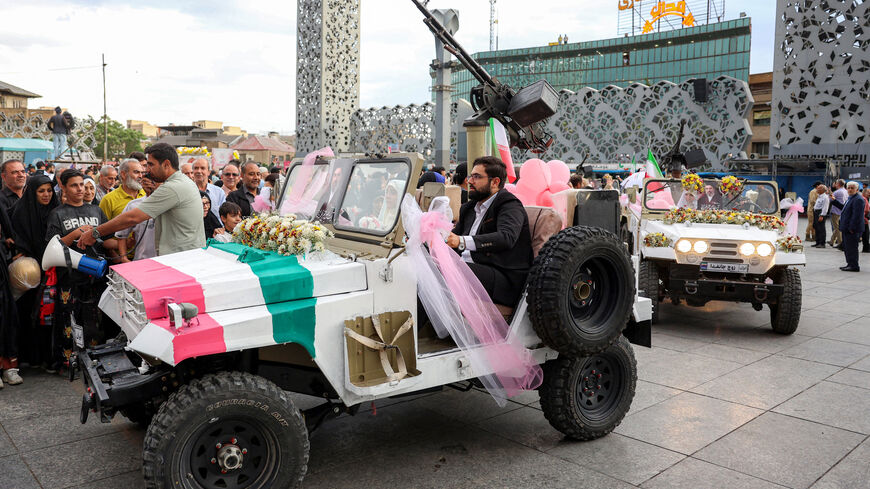 A bride and group couple rides in a military jeep arriving for a public mass wedding ceremony at Imam Hossein Square in Tehran on May 18, 2026. Iran said on May 18 that it had responded to a new US proposal aimed at ending the war, adding that diplomatic exchanges continue despite Iranian media reports describing Washington's demands as excessive. Washington and Tehran have been swapping proposals in an effort to end the conflict which the US and Israel launched on February 28, but they have held only a sin