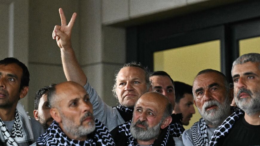 Members of a Gaza-bound flotilla pose outside a terminal following their arrival at Istanbul airport