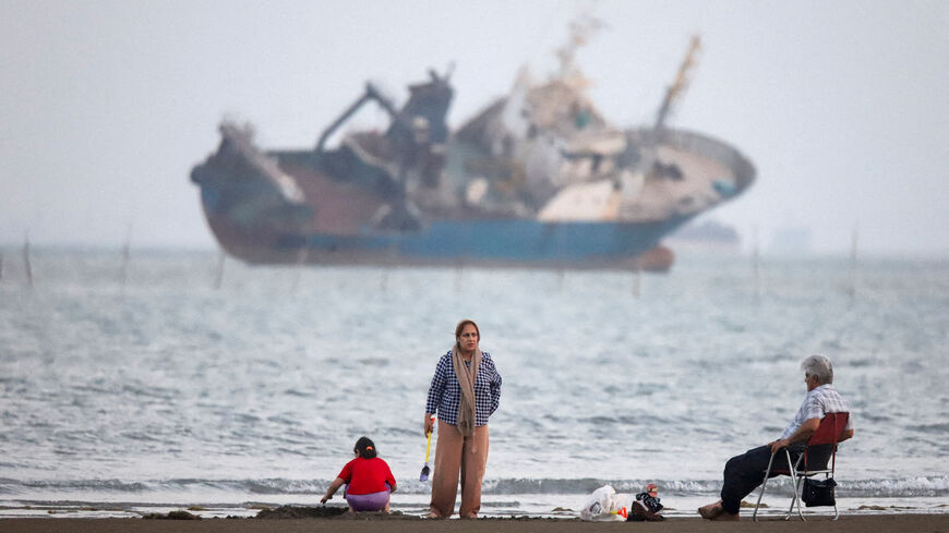 FILE PHOTO: People gather on a beach, as a vessel in the Strait of Hormuz is visible, near the beach of Bandar Abbas, Iran, May 31, 2026. Amirhosein Khorgooi/ISNA/WANA (West Asia News Agency) via REUTERS/File Photo