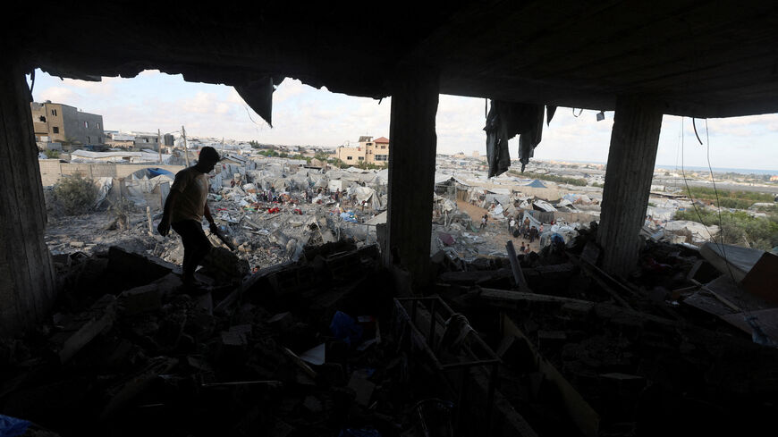 A Palestinian man inspects the site of an Israeli strike on a house whose residents were warned to evacuate before the attack, near a tent camp sheltering displaced people that was damaged in the strike, in Khan Younis in the southern Gaza Strip June 7, 2026. REUTERS/Ramadan Abed