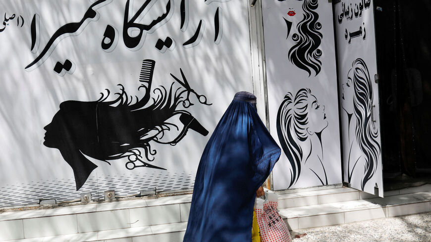 FILE PHOTO: An Afghan woman walks past a beauty salon in Kabul, Afghanistan, July 6, 2023. REUTERS/Ali Khara/File Photo