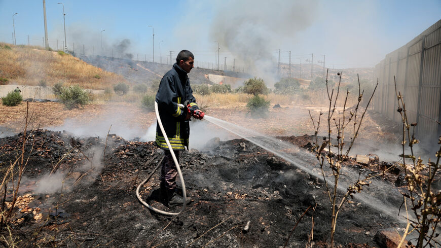 A Palestinian man rushes to extinguish fire in a field, which local Palestinians say has been set by Israeli settlers, in the town of Huwwara near Nablus, in the Israeli-occupied West Bank, June 6, 2026. REUTERS/Mohamad Torokman