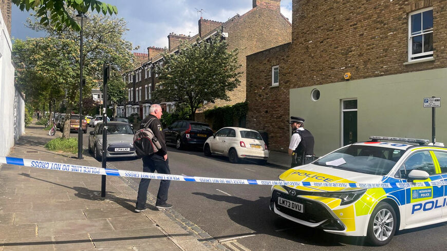 A person walks to a police officer at a cordoned off street, where a fire broke out at Britain's Prime Minister Keir Starmer's home in the early hours of Monday, in north London, Britain, May 12, 2025. REUTERS/Paul Sandle