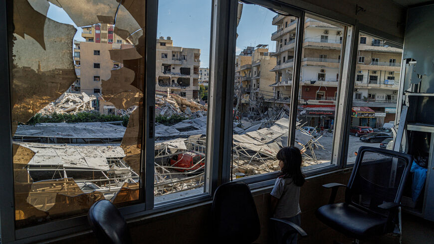 A displaced girl stands at the broken window of Jabal Amel hospital where she has taken shelter with her family, overlooking buildings damaged by Israeli strikes, following a deal between the U.S. and Iran, in Tyre, southern Lebanon, June 16, 2026. REUTERS/Zohra Bensemra