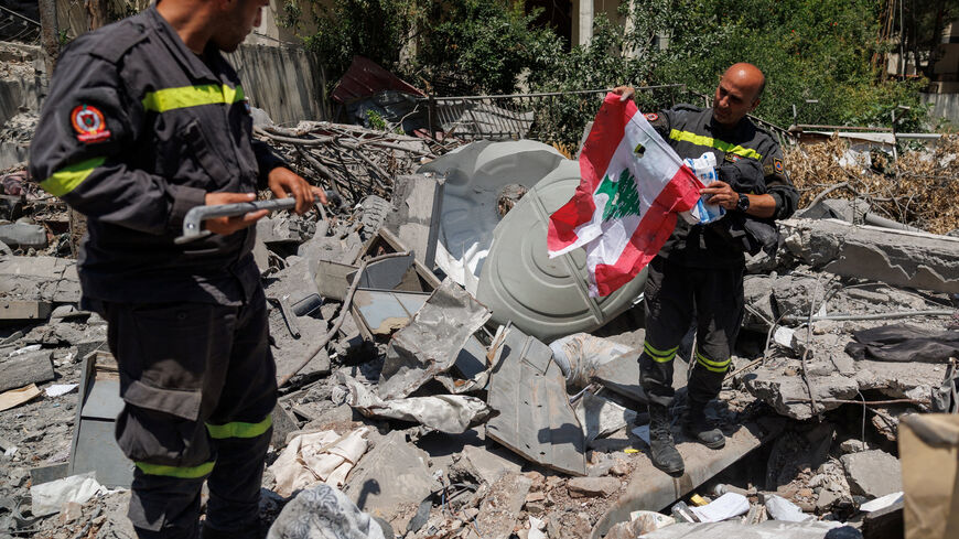 A member of the government-run Lebanese Civil Defense, the country's primary firefighting, first aid, and rescue force, holds a Lebanese flag salvaged from the rubble while inspecting their headquarters in Nabatieh, Lebanon, June 17, 2026, following the deal between the United States and Iran. The headquarters was destroyed in an Israeli airstrike in May. REUTERS/Zohra Bensemra