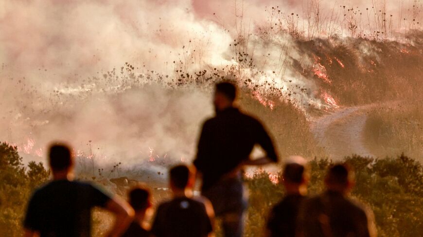 Palestinians watchrf as a fire blazed near the village of Tell, adjacent to the Israeli settlement of Havat Gilad, west of Nablus in the occupied West Bank