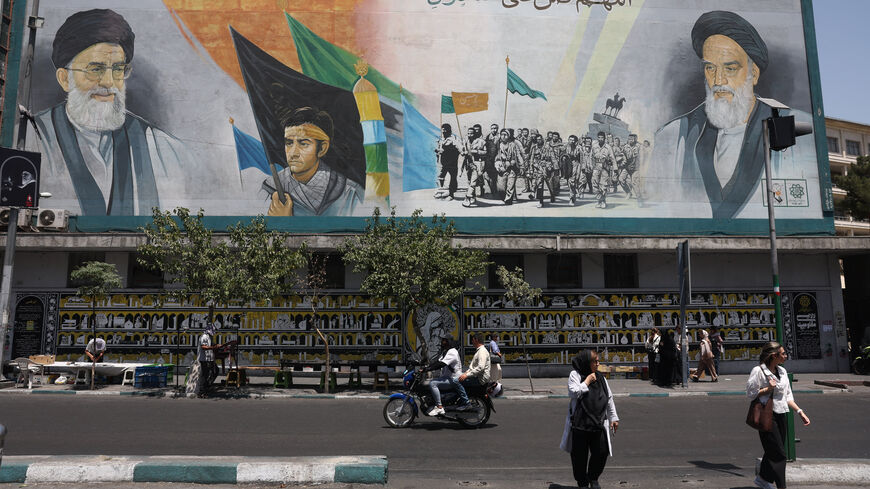 People walk past a mural depicting the late leader of the Islamic Revolution, Ayatollah Ruhollah Khomeini, and Iran's late Supreme Leader Ayatollah Ali Khamenei, on a street in Tehran, Iran, July 15, 2026. Majid Asgaripour/WANA (West Asia News Agency) via REUTERS
