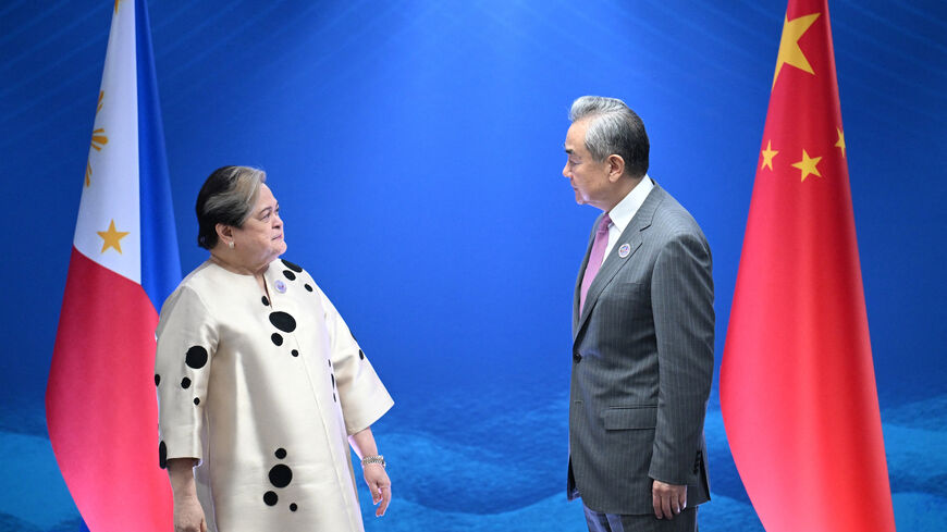 Philippine Foreign Secretary Theresa Lazaro talks to China's Foreign Minister Wang Yi during their bilateral meeting on the sidelines of the Association of Southeast Asian Nations (ASEAN) Foreign Ministers' Meeting in Pasay, Metro Manila on July 22, 2026.     TED ALJIBE/Pool via REUTERS