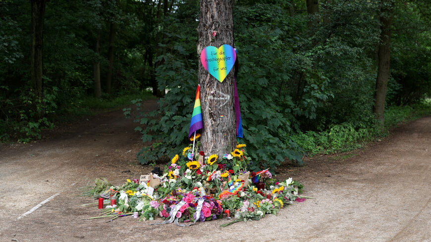 A view of a makeshift memorial at Tiergarten park after a deadly incident in which a vehicle crashed into a crowd near Berlin's annual Christopher Street Day Pride parade on Saturday evening, leaving multiple people injured and the parade called off, in Berlin, Germany, July 27, 2026. The placard reads: "We honor all the victims and survivors. We will not allow ourselves to be divided". REUTERS/Christian Mang