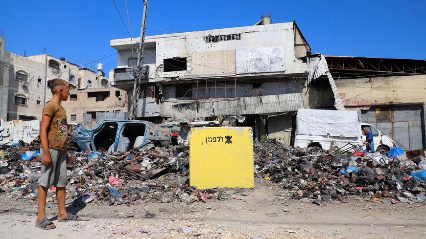 A Palestinian boy looks at a yellow concrete block marking the "yellow zone" under Israeli military control, in Tufah neighborhood, in Gaza City, July 27, 2026. REUTERS/Ebrahim Hajjaj