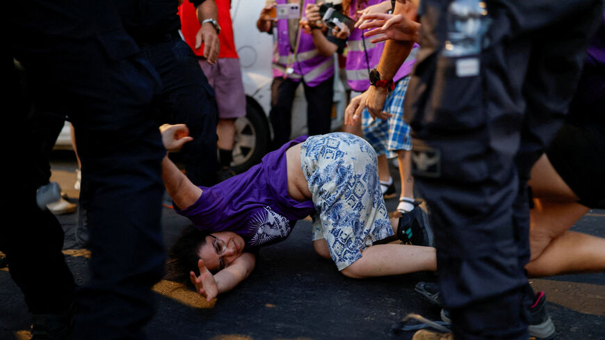 Israeli security personnel hold an activist during a protest against violence committed by Israeli settlers against Palestinians in the occupied West Bank, in Tel Aviv, Israel, July 28, 2026. REUTERS/Amir Cohen